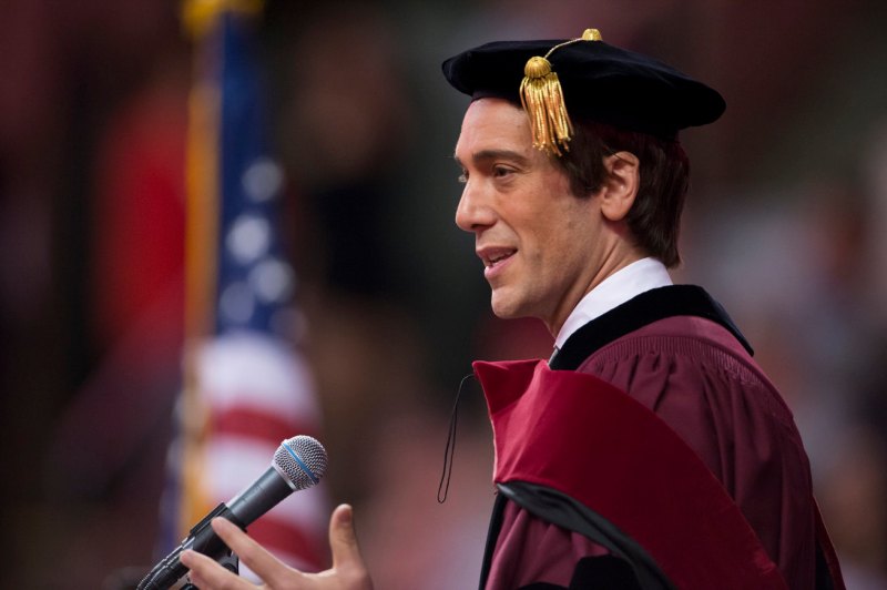 David Muir in Commencement regalia, speaking at the podium