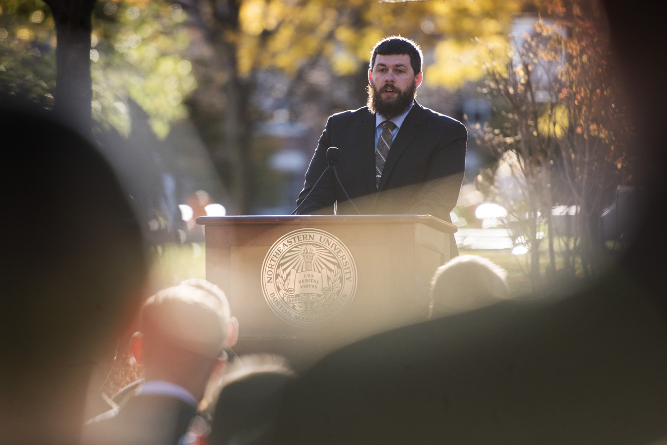 John McGuiness, E'19, president of the Student Veterans Organization, addresses the crowd at the Veterans Day ceremony. <i>Photo by Adam Glanzman/Northeastern University</i>