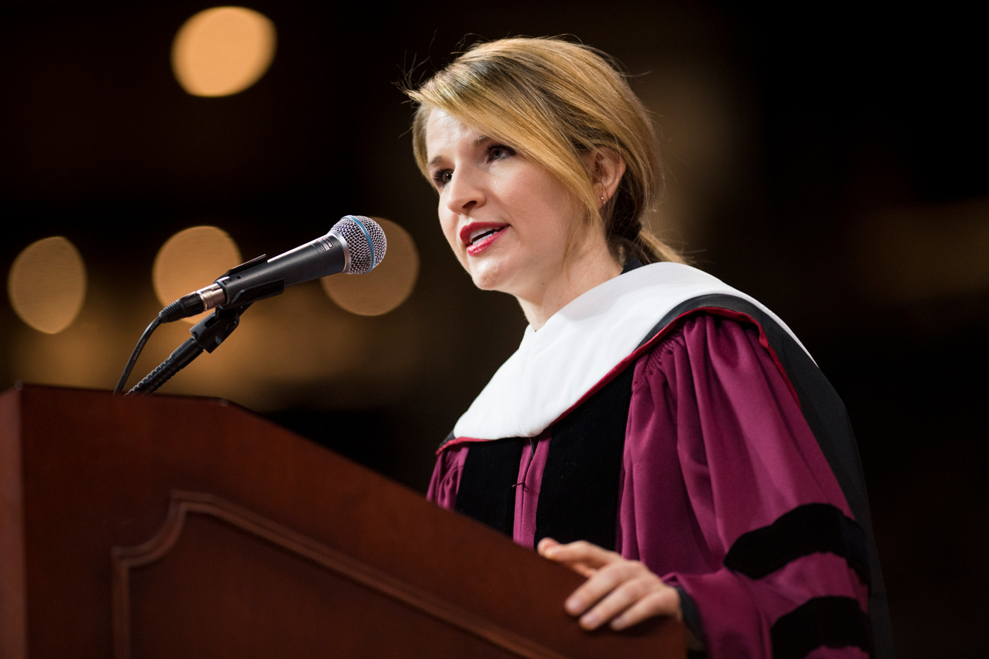 Tara Westover in Commencement regalia, speaking at the podium