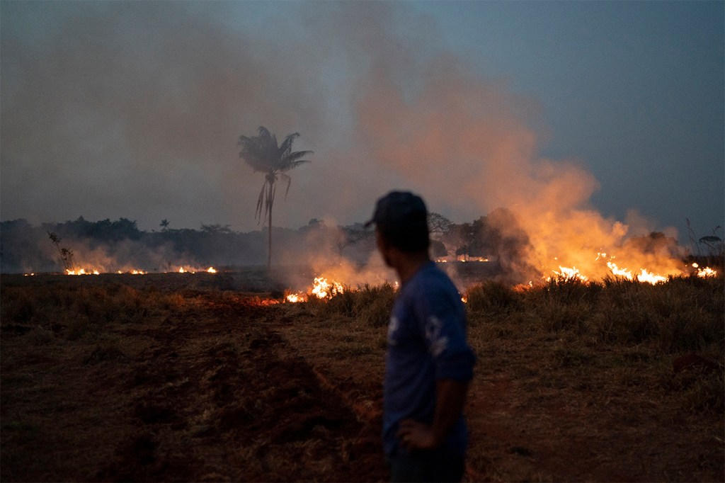 Neri dos Santos Silva watches an encroaching fire threat after digging trenches to keep the flames from spreading to the farm he works on, in the Nova Santa Helena municipality, in the state of Mato Grosso, Brazil, on Friday, Aug. 23, 2019. Under increasing international pressure to contain fires sweeping parts of the Amazon, Brazilian President Jair Bolsonaro recently authorized use of the military to battle the massive blazes. AP Photo/Leo Correa