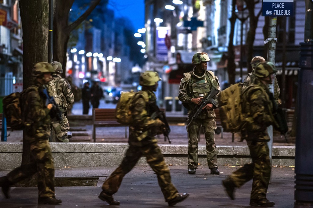 Special Police, Army, and other units move toward the scene in Paris suburb Saint-Denis on Wednesday, Nov. 18, 2015. Heavily armed police surrounded a suburban Paris apartment in a raid targeting the suspected mastermind of the Paris attacks. Credit: KAMIL ZIHNIOGLOU/Sipa via AP Images