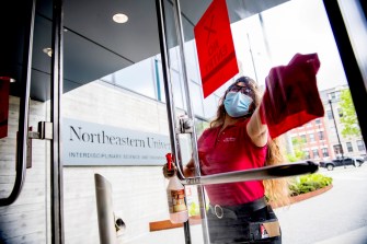 Worker cleans a table on campus