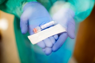 image of person holding anterior nasal swab kit