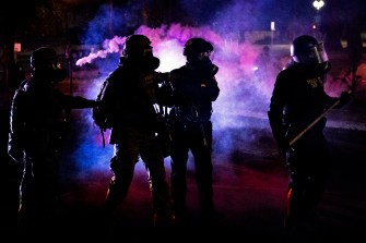 picture of protestors clashing with federal agents in Portland in July