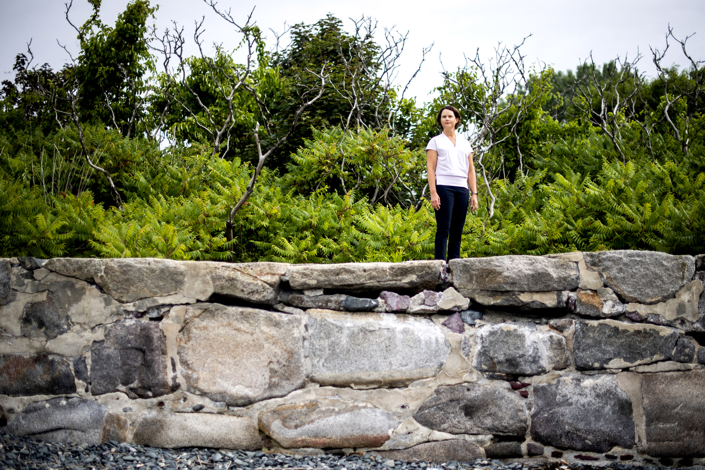 Randall Hughes standing outside on a rock wall.