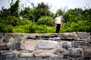 Randall Hughes standing outside on a rock wall.