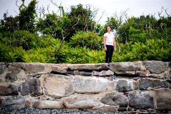 Randall Hughes standing outside on a rock wall.