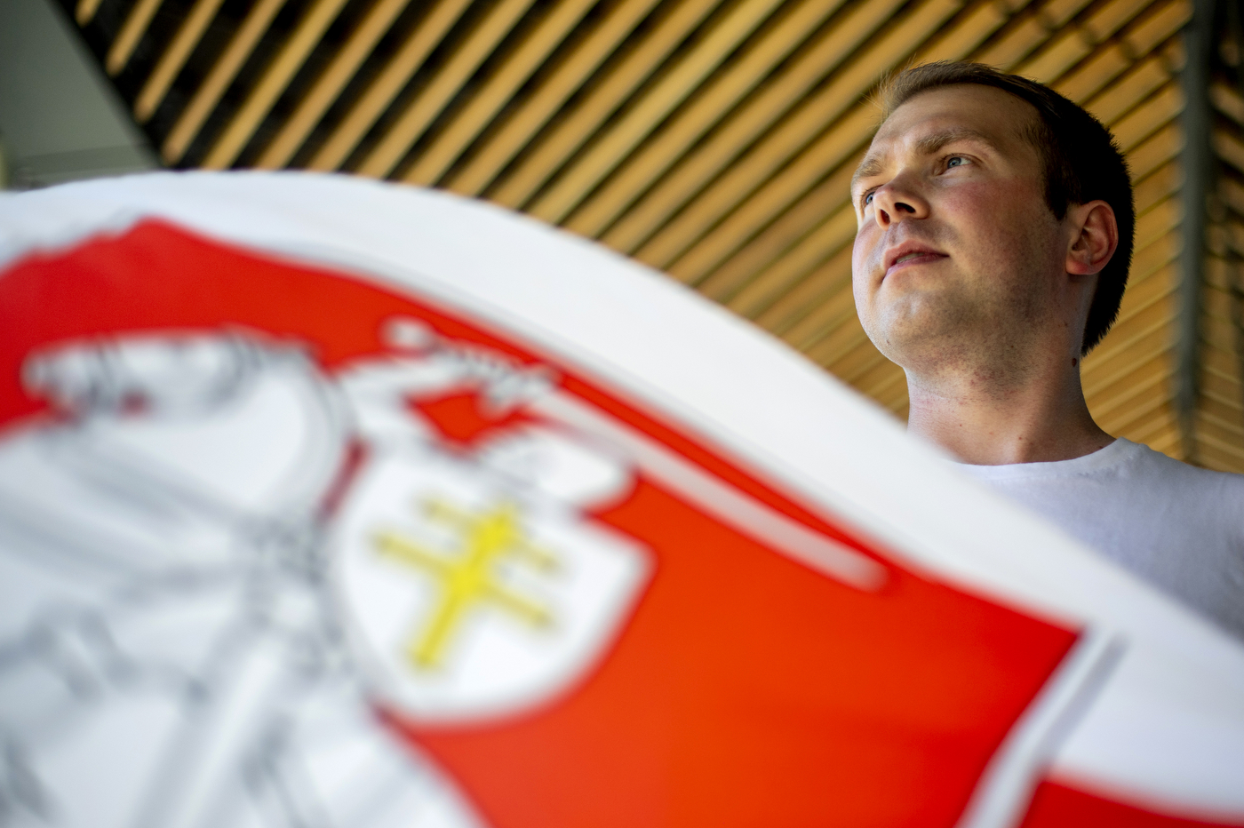 Northeastern student Alexey Petrusevich poses with a Pahonia flag that is being used by the peaceful protesters in Belarus as a symbol of freedom and independence. Photo by Ruby Wallau/Northeastern University