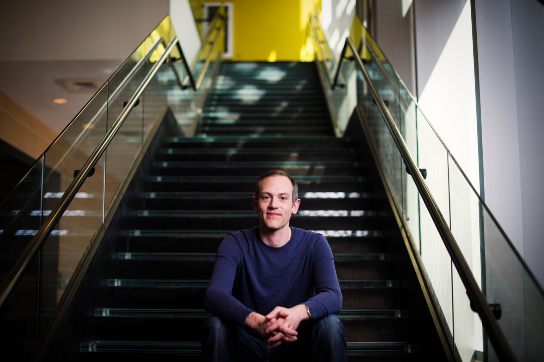 Picture of David Choffnes sitting on the steps of a campus building.