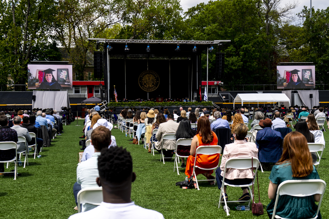 Guests seated on chairs during graduation ceremony.