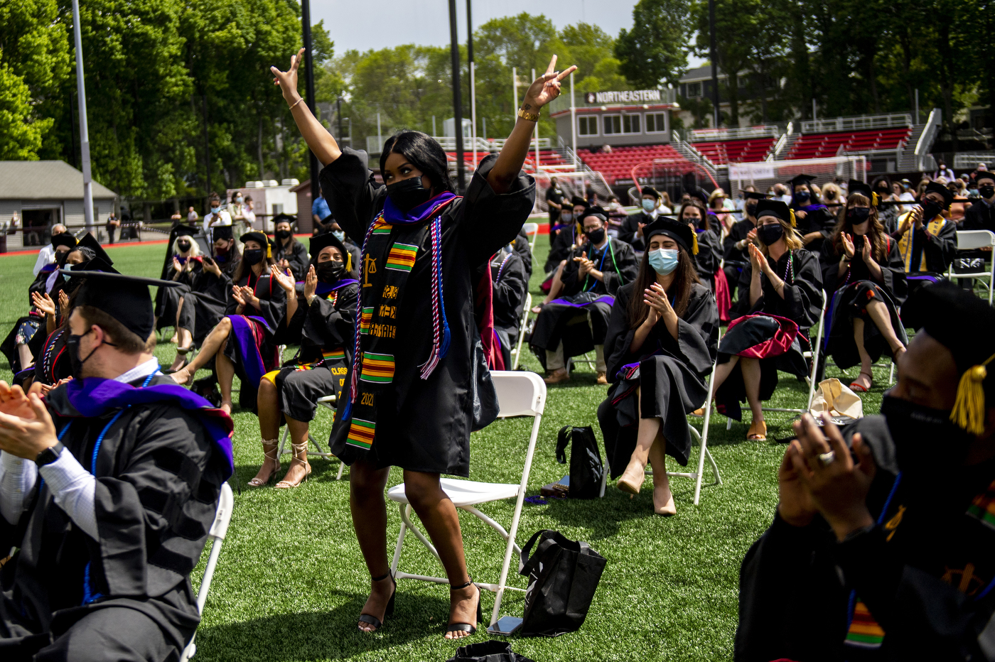 Student standing with arms raised in celebration