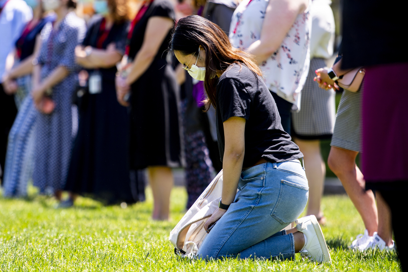 A woman kneels at the Moment of Reflection for George Floyd