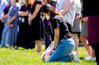 A woman kneels at the Moment of Reflection for George Floyd