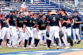 The Huskies gather at home plate to celebrate Max Viera's home run.