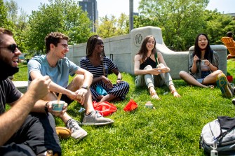 Students sitting on the grass on theBoston campus