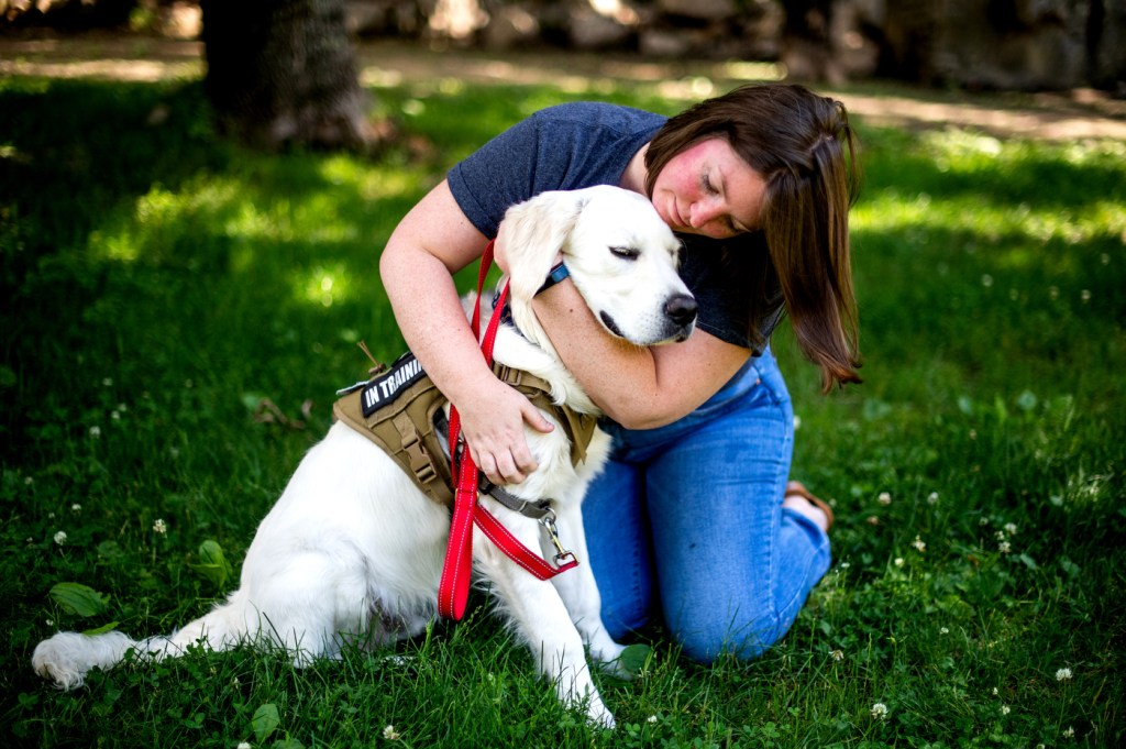 Woman hugs a golden retriever