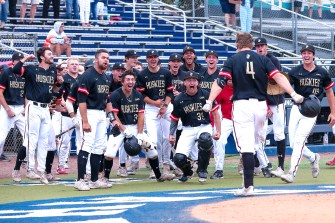 Huskies celebrate the walk-off home run that won the CAA title.