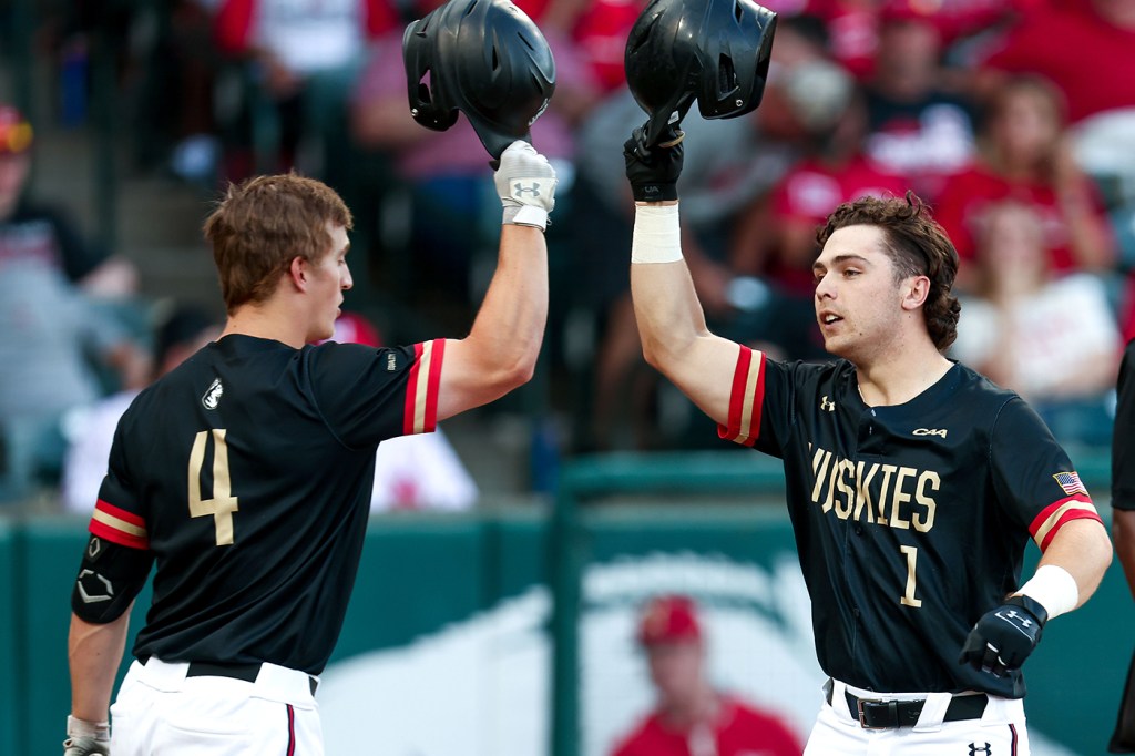 Ben Malgeri (left) and Danny Crossen greet each other during a Huskies baseball game.