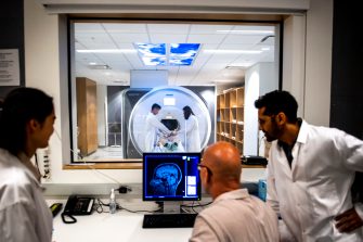 Technicians oversee an MRI exam.