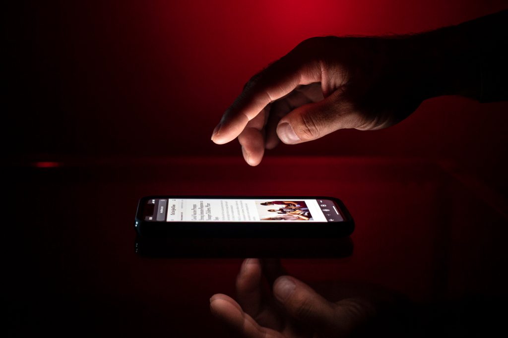 hand raised over iphone preparing to start doomscrolling