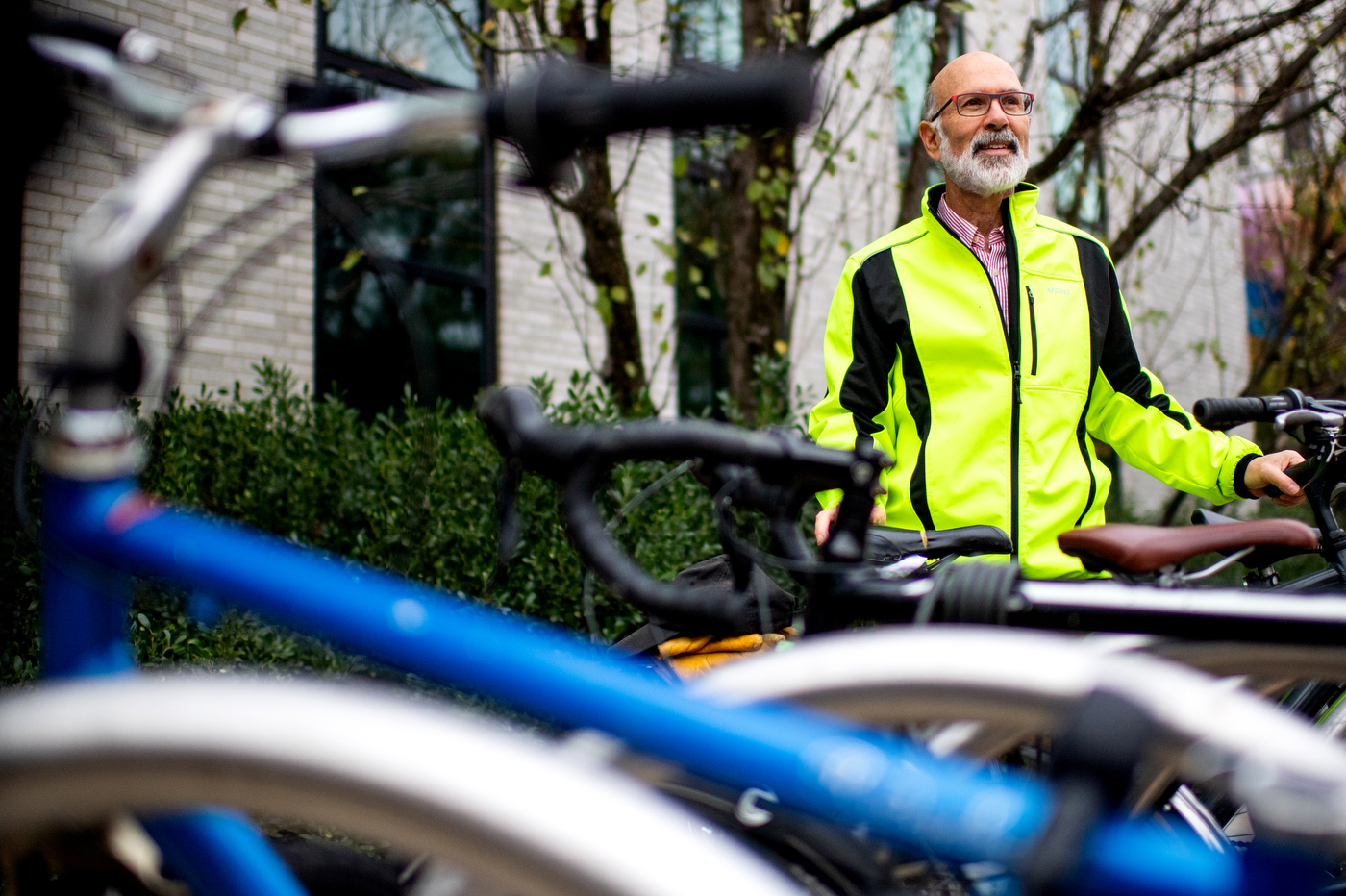 peter furth wearing neon green jacket standing next to bike rack