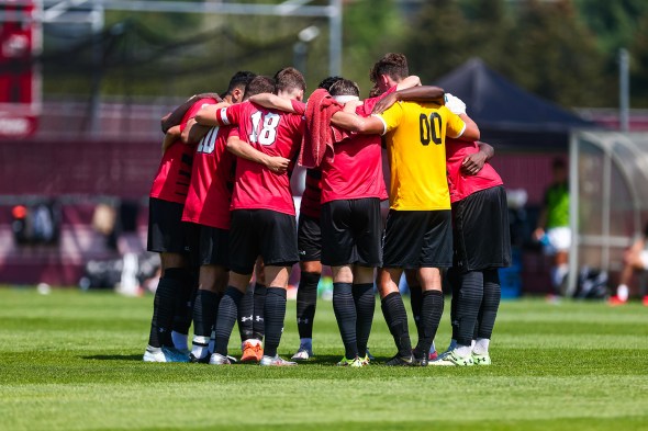 Huskies soccer team huddles.