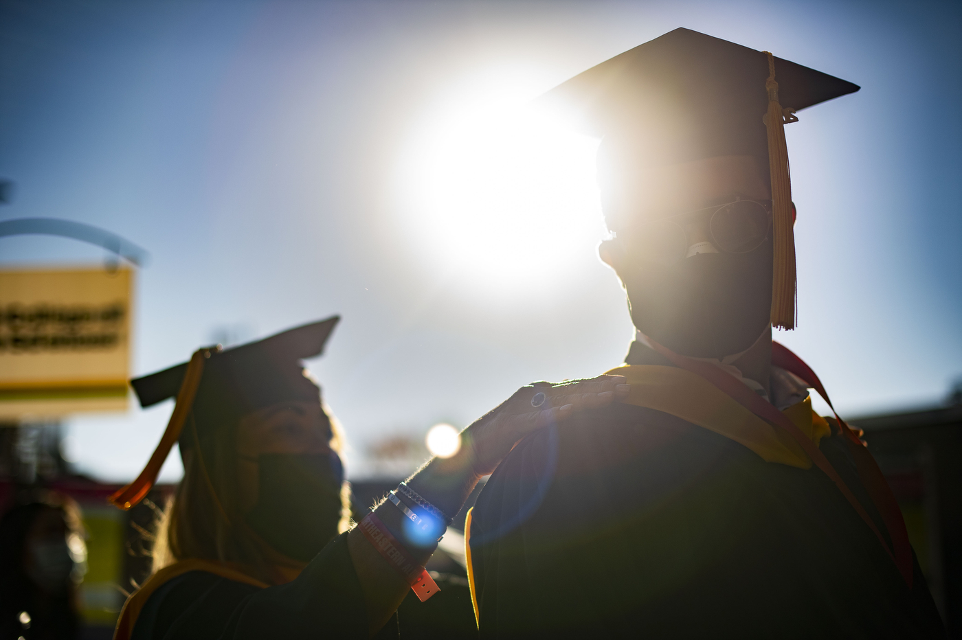 People in graduation caps silhouetted against the sky