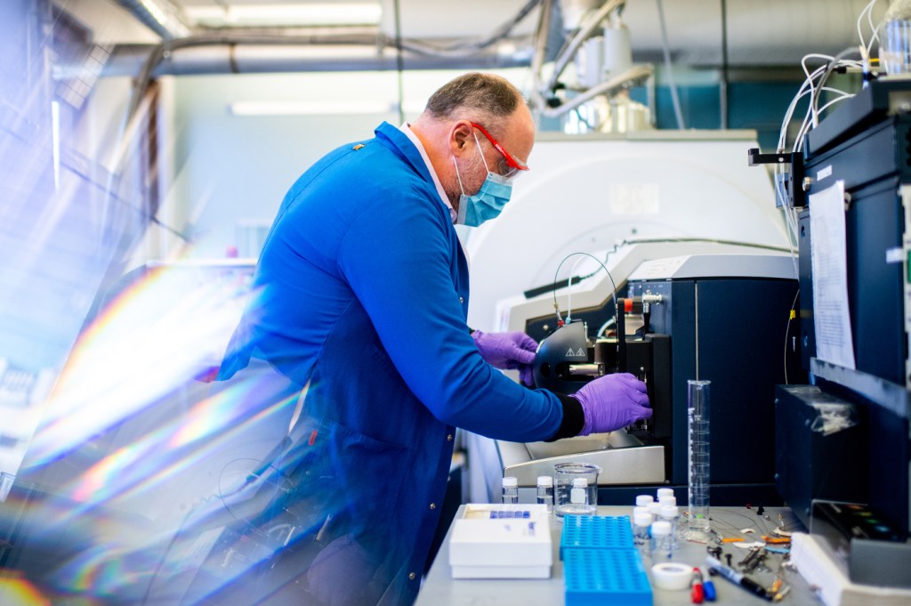 man with purple gloves in lab testing subject