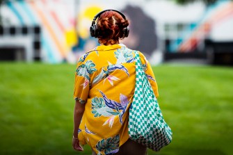 back of a student wearing yellow shirt and headphones