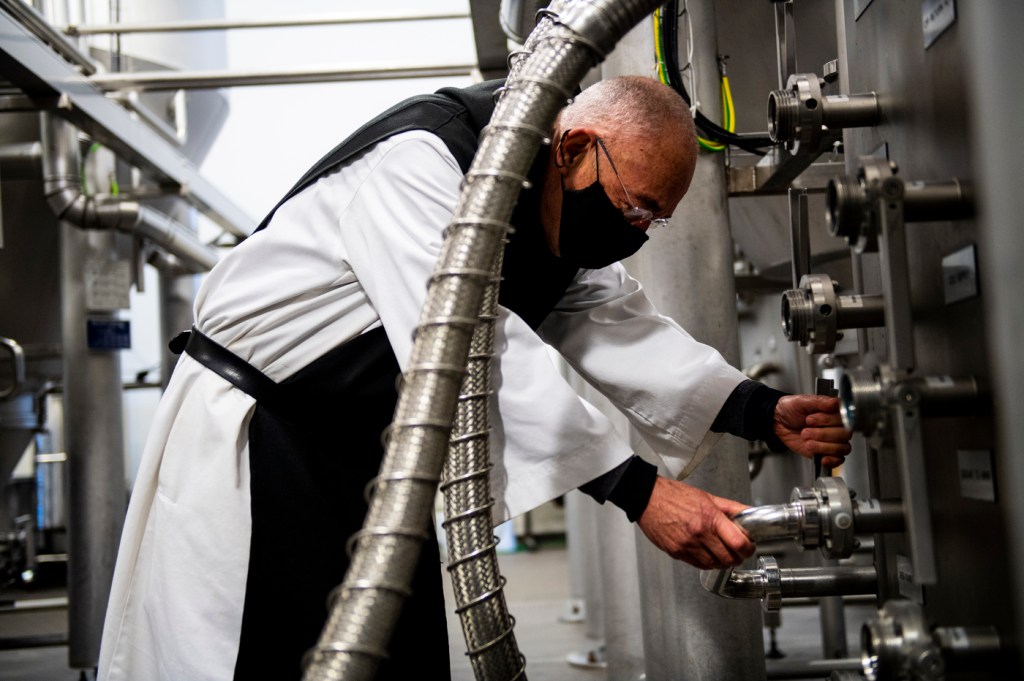 Father Isaac Keeley checks the fermentation of the beer at Spencer Brewery in Spencer, MA.