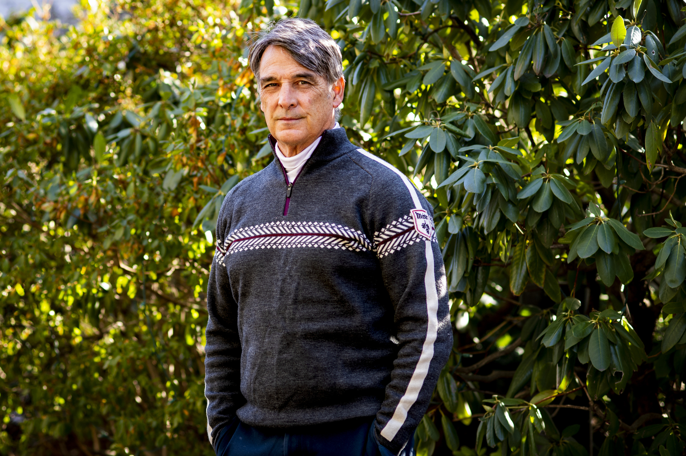 russ o'haver stands in front of greenery with his hands in his pockets