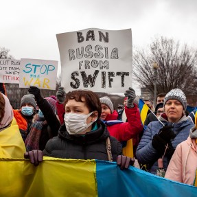 Protesters demand that Russia be banned from the SWIFT system during a rally for Ukraine at the White House. This system facilitates international interbank transactions, and banning Russia would severely curtail business transactions and banking. Hundreds of people protested following Russia's overnight invasion of Ukraine to demand sanctions on Russia and military assistance for Ukraine. The event was sponsored by United Help Ukraine, a U.S.-based assistance and advocacy organization.