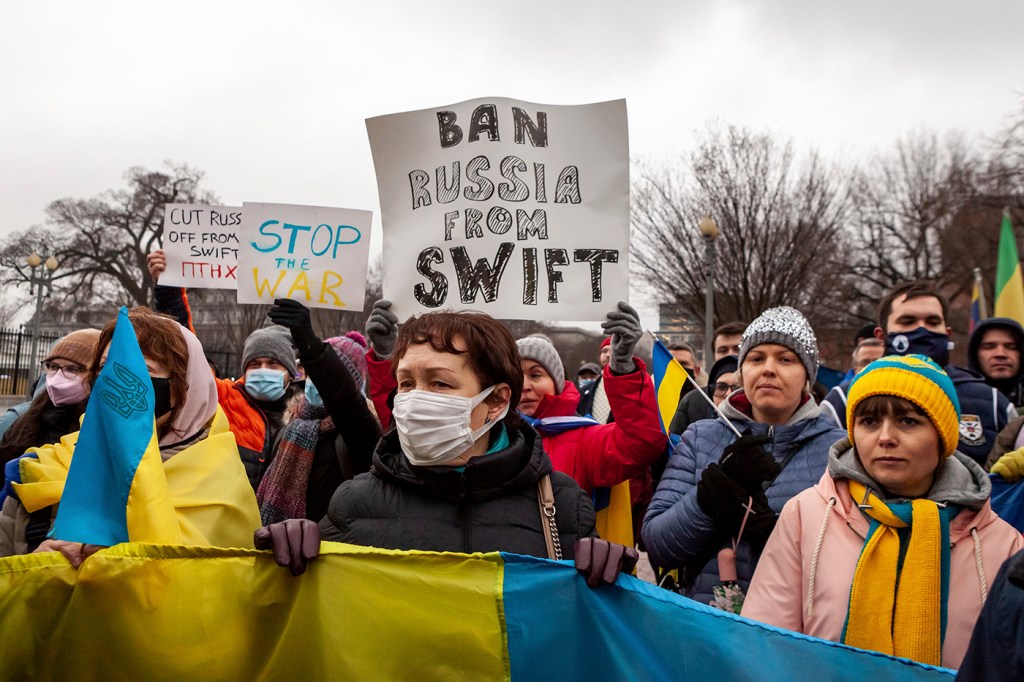 Protesters demand that Russia be banned from the SWIFT system during a rally for Ukraine at the White House. This system facilitates international interbank transactions, and banning Russia would severely curtail business transactions and banking. Hundreds of people protested following Russia's overnight invasion of Ukraine to demand sanctions on Russia and military assistance for Ukraine. The event was sponsored by United Help Ukraine, a U.S.-based assistance and advocacy organization.