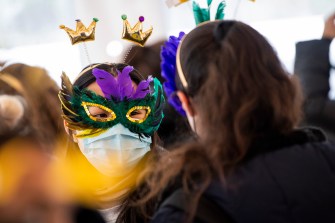 student wearing mardi gras mask