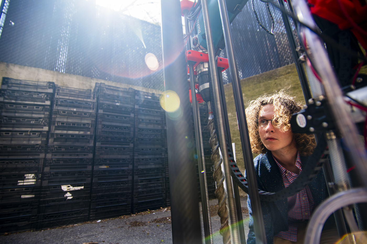 Samuel crouches down to look up underneath part of the machine