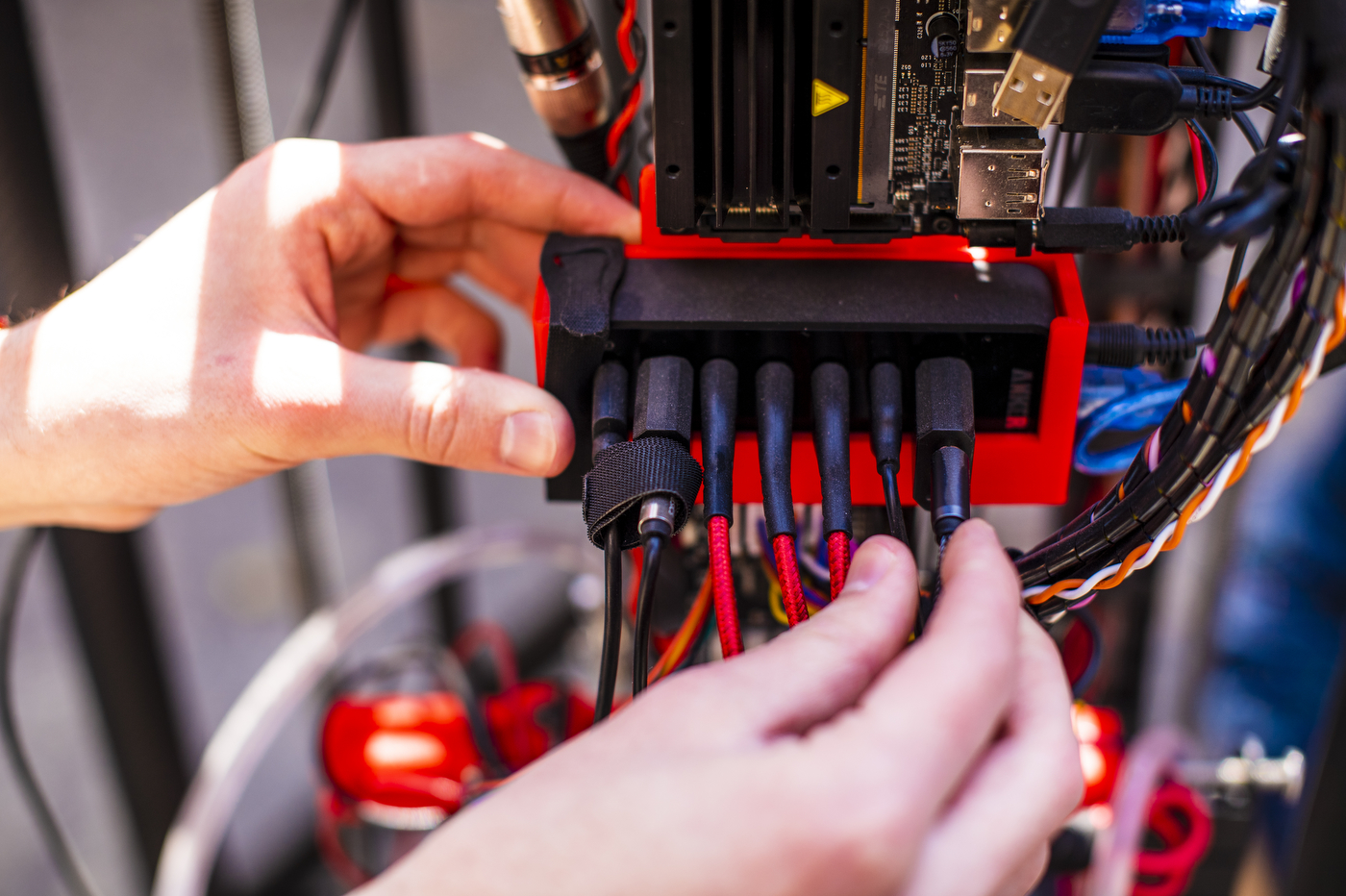 Two hands ensure that 7 wires are firmly attached