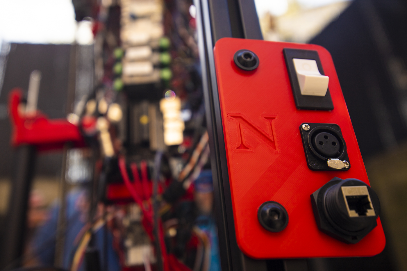 A control panel with a large white switch, and a red plate engraved with the Northeastern N