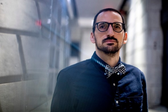 man wearing button down shirt, bowtie and glasses