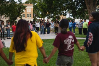 community members hold hands in a large circle