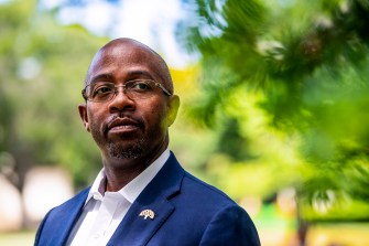 man wearing blue suit jacket, white shirt and glasses