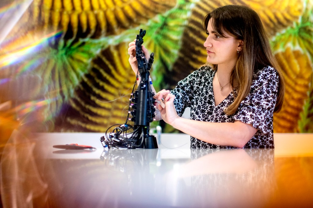 woman examining robotic arm