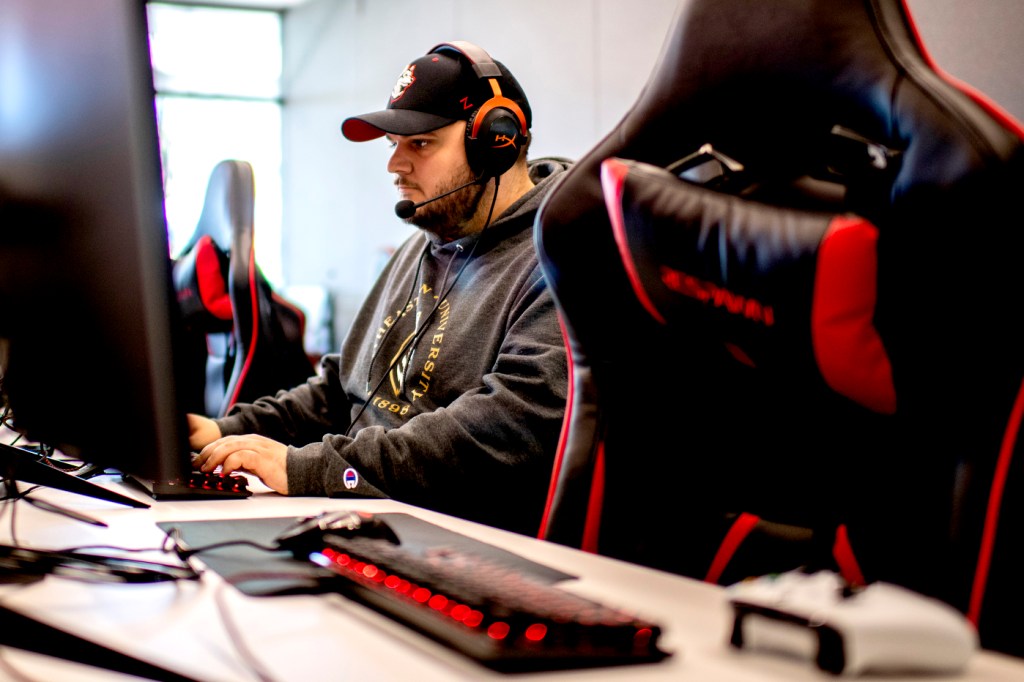 man sitting at a computer gaming with headphones on