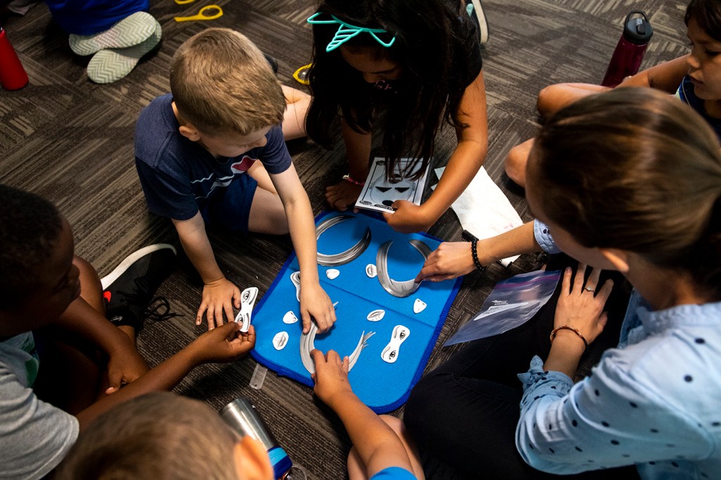 students huddle around a word game