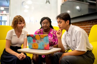 students sitting around a laptop