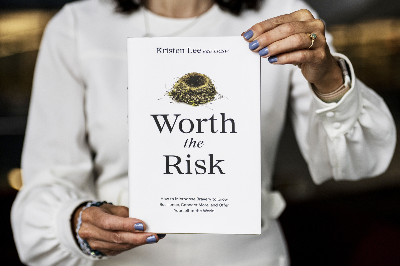 white book with black title 'worth the risk' underneath the picture of a birds nest