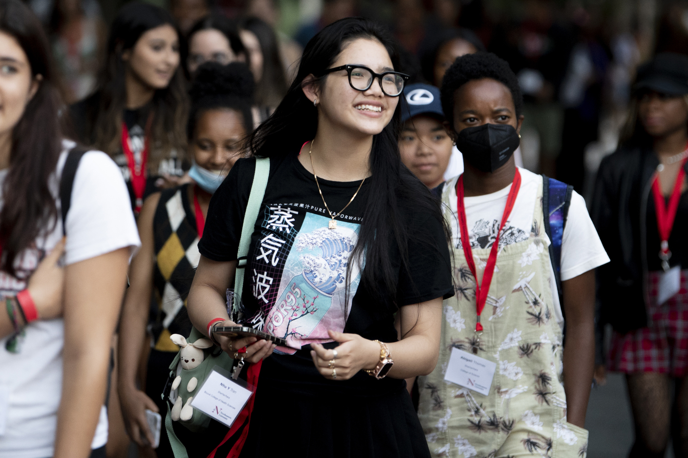 A group of students walking, the foremost looking hopeful and excited