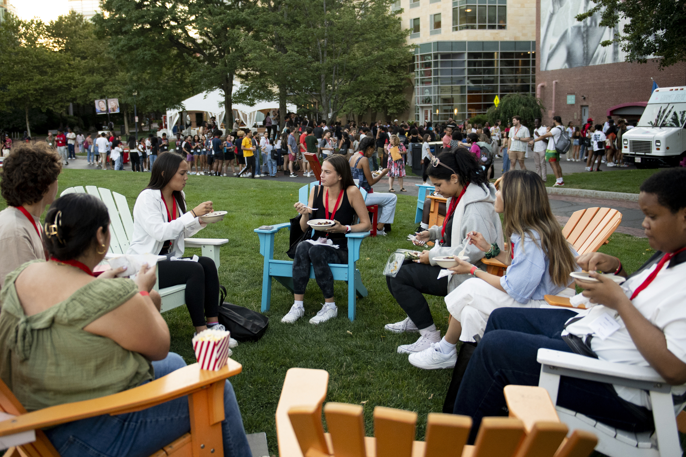 A group of students sit in patio chairs outside