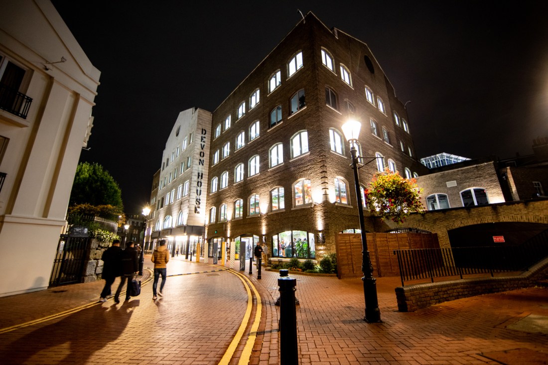 people walking on brick pathway next to large stone building in london at night