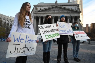 protesters holding signs outside of the courthouse at maxwell's trial