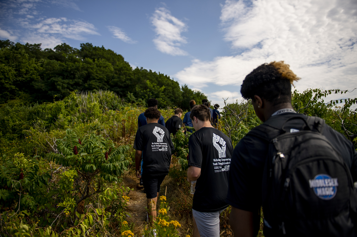 Students in matching T-shirts walk the path to the beach